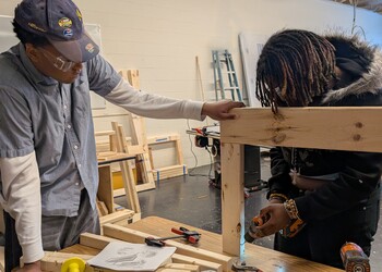 Sophomore MPS Students Kaeden Smith (l) and Ja'Ziiyah Wyrick (r) apply math concepts to build flower boxes in their Geometry in Construction class
